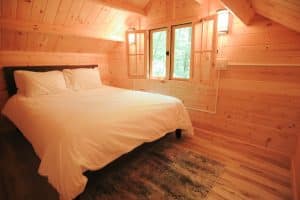 cozy queen size bed in a glamping cabin on the peshtigo river