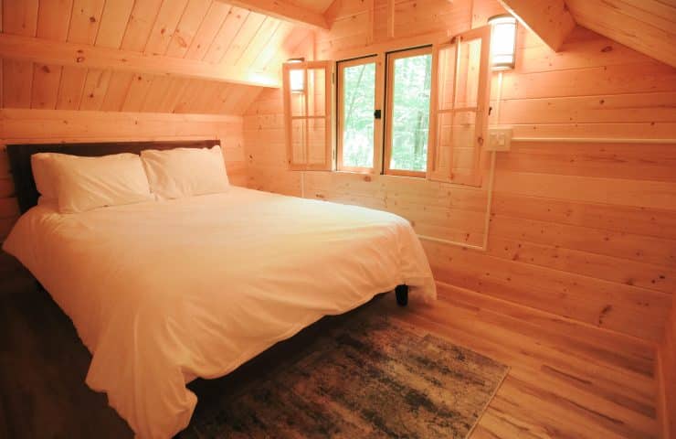 cozy queen size bed in a glamping cabin on the peshtigo river