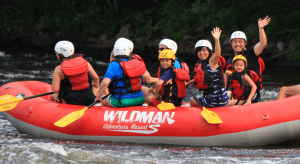 A family in a raft waves to the camera after their trip