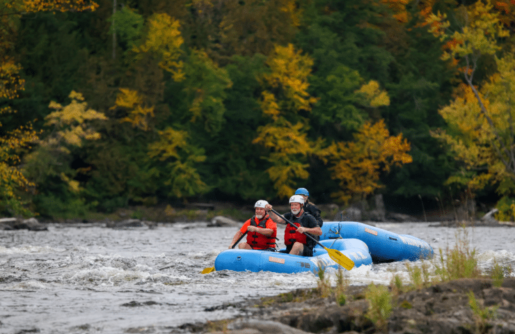 a small whitewater raft surrounded by fall foliage