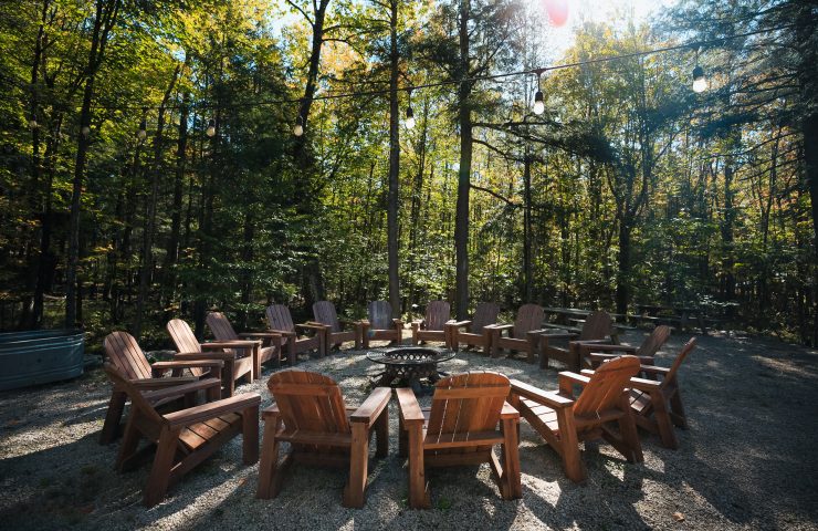 A circle of Adirondack chairs around a firepit at Wildman Adventure Resort