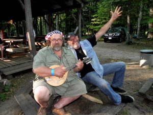 Two men enjoying some music, playing a mandolin