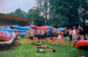 group of wildman employees by a stack of rafts