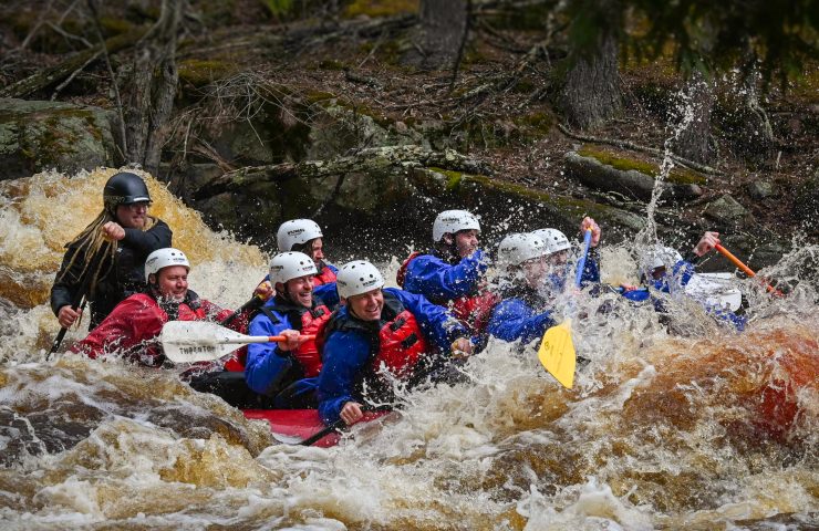 a group of people whitewater rafting on the peshtigo river wisconsin in spring